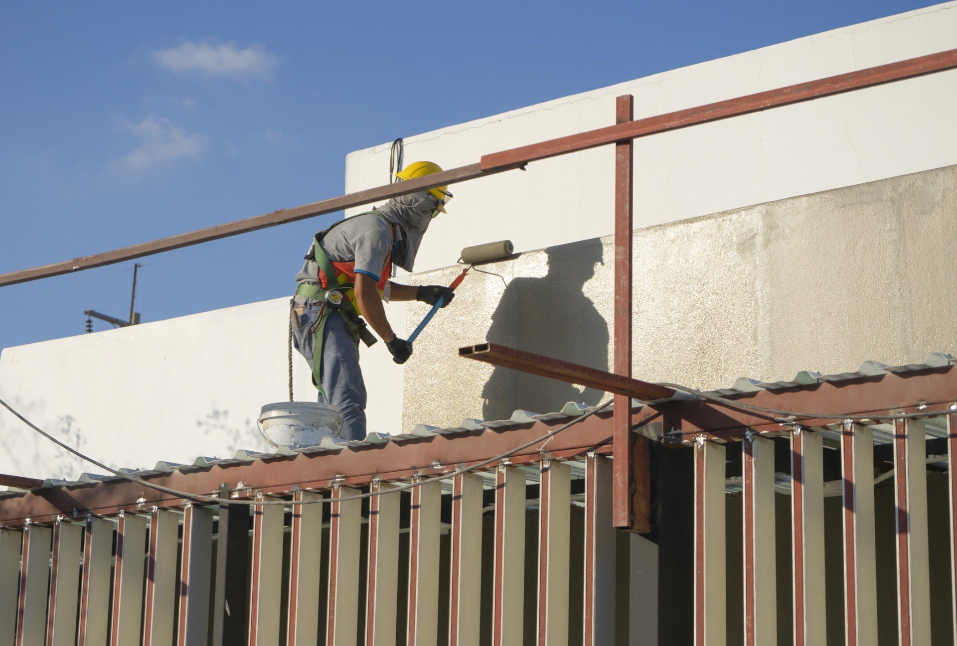 A man is painting a wall with a roller