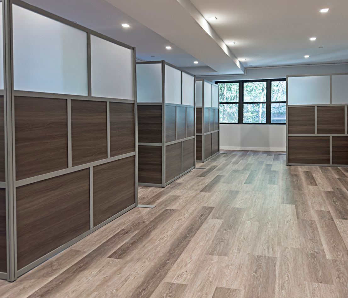 a row of cubicles in an office with wooden floors