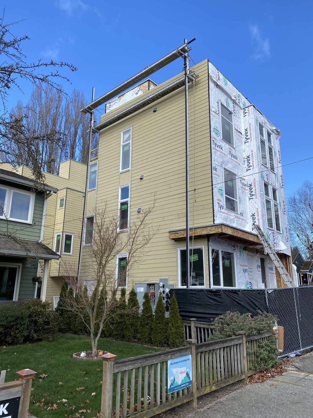 A large yellow building is being remodeled with scaffolding.