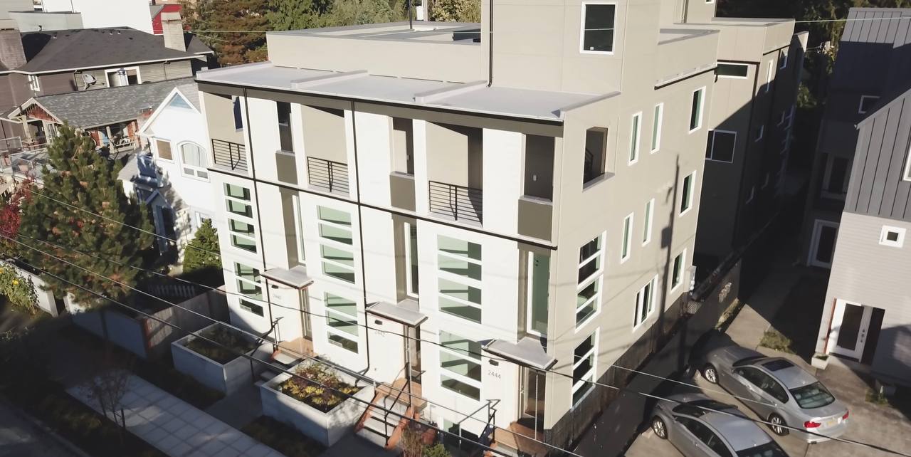 An aerial view of a building with cars parked in front of it.