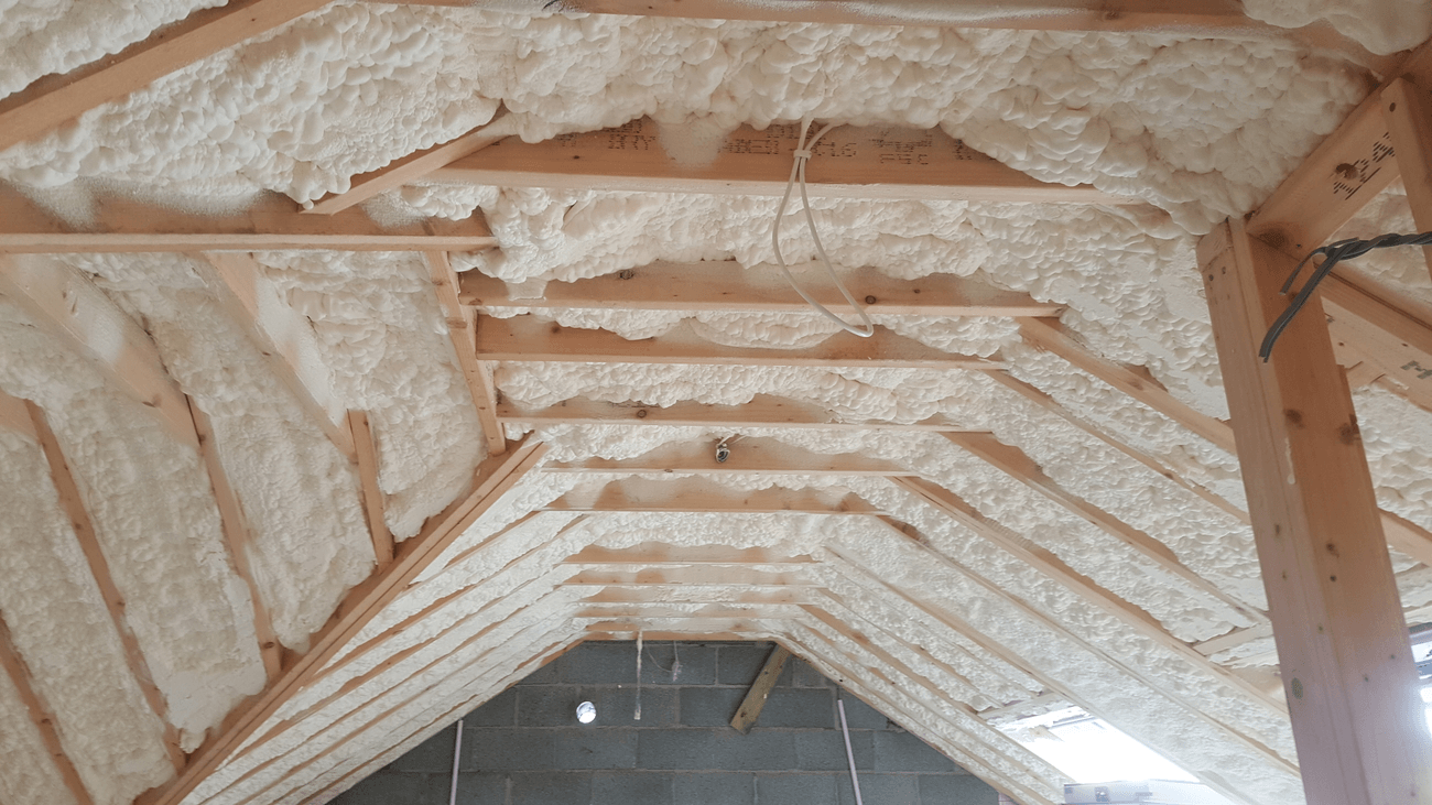 The ceiling of a house is covered in foam and wooden beams.