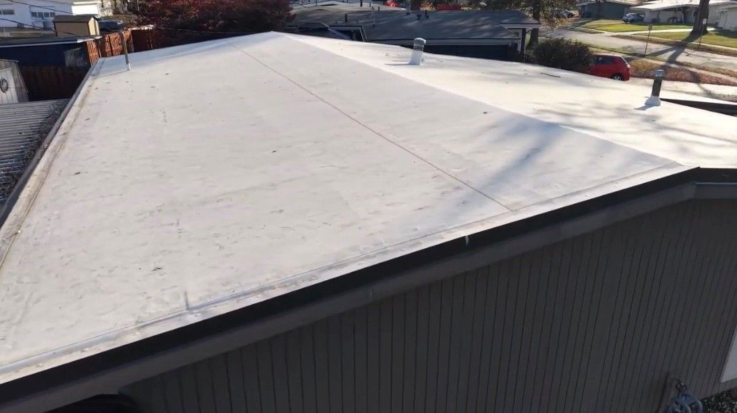 Workers installing a commercial roof membrane.