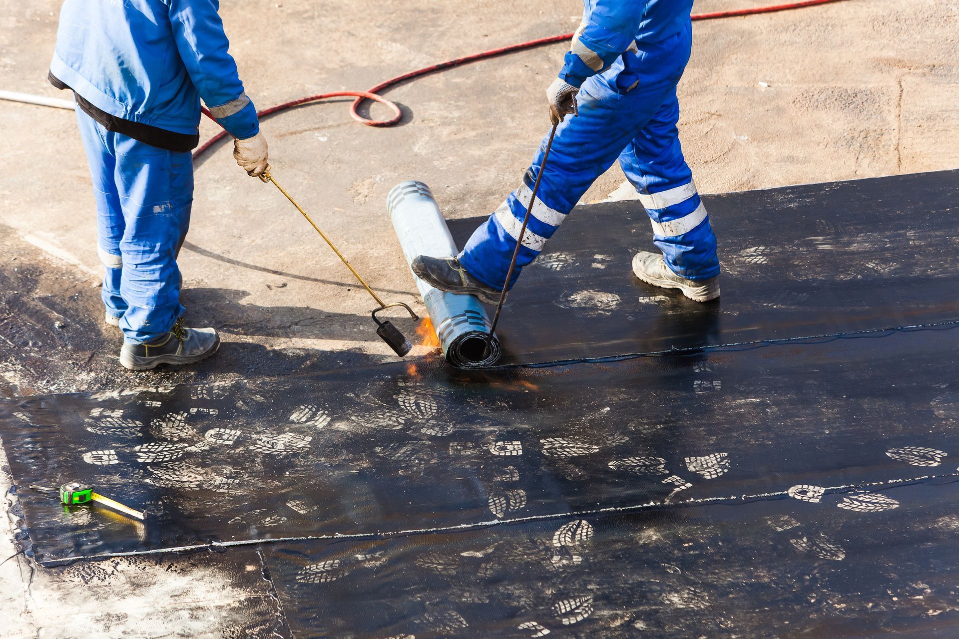 Professional roofers from Allied Roofing installing a durable modified bitumen roof on a commercial 