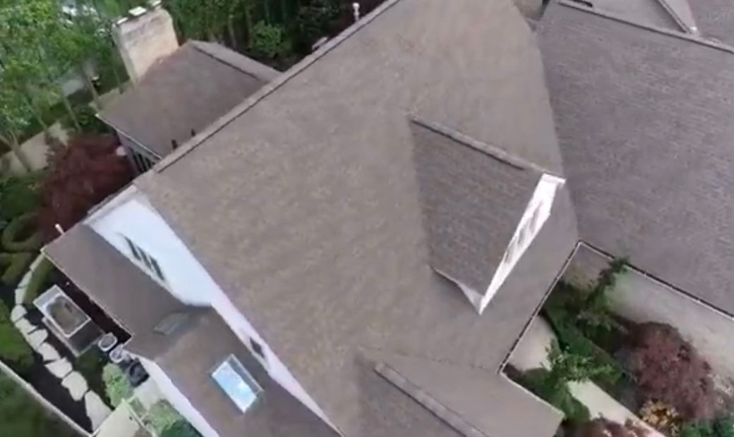 An aerial view of a house with a roof and a chimney.