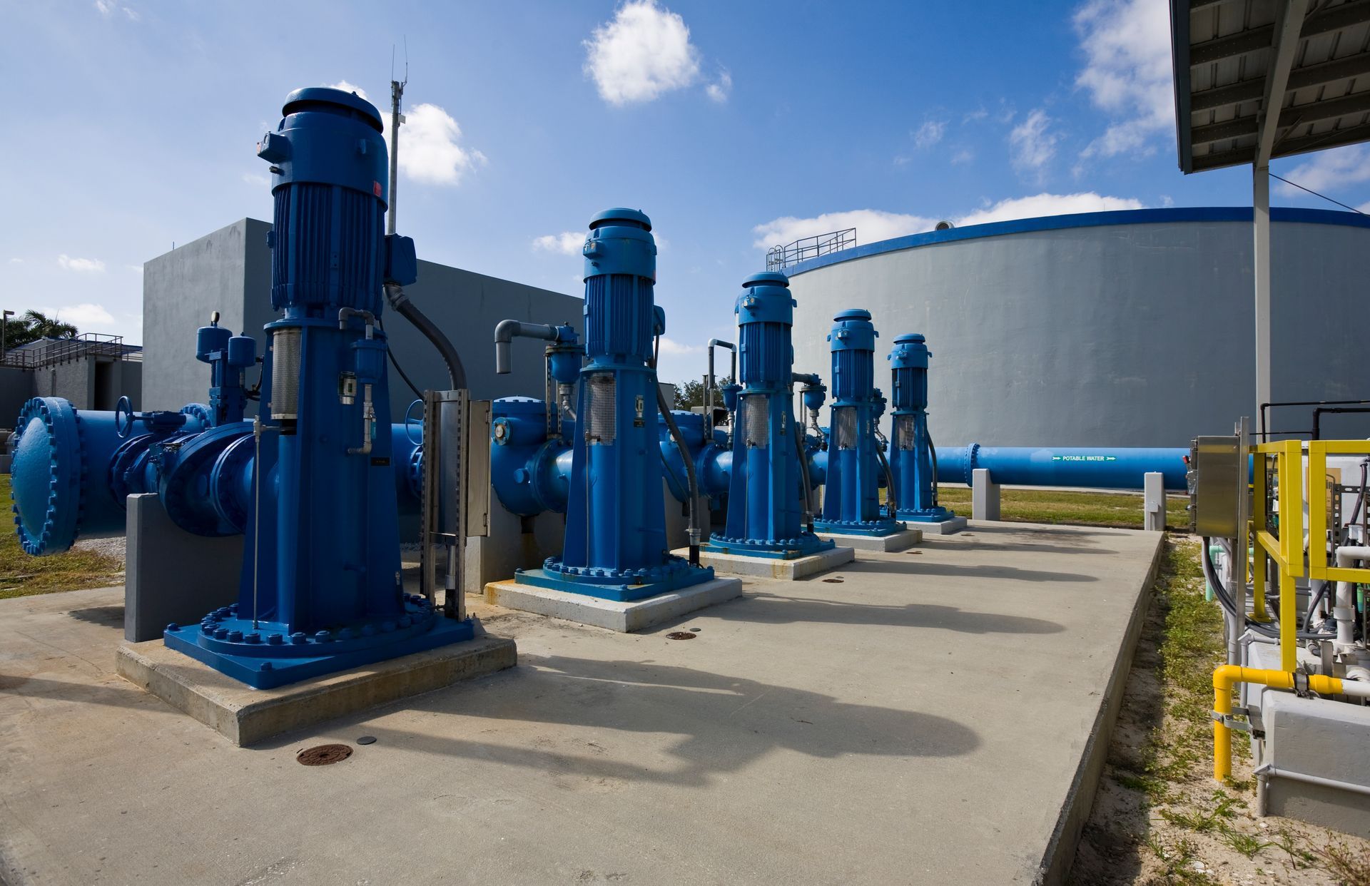 A row of blue pumps are lined up in front of a building