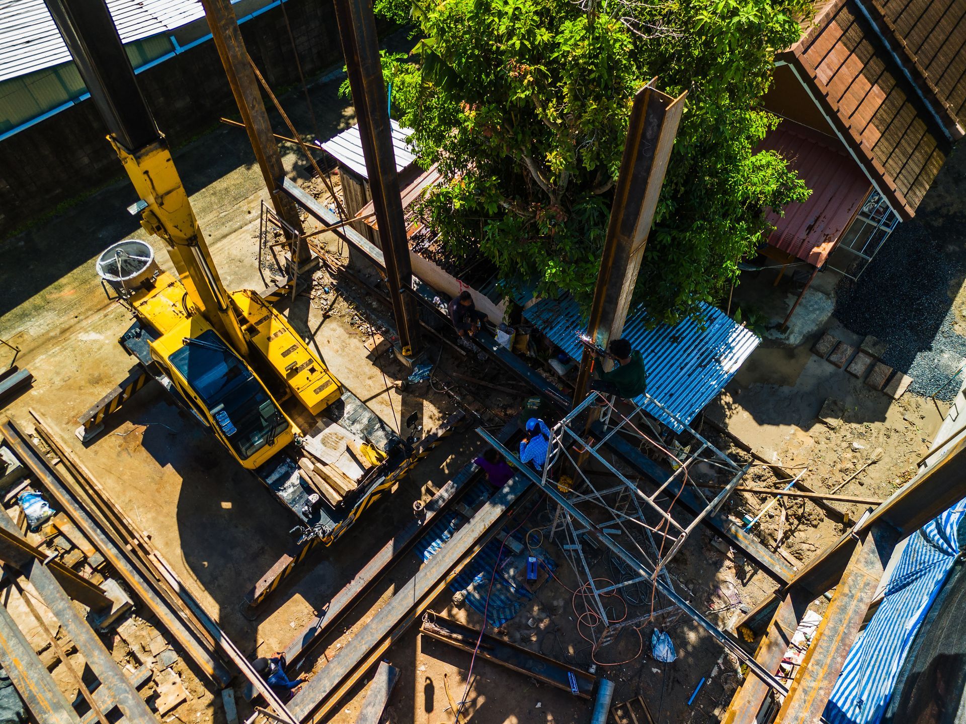 An aerial view of a construction site with a yellow crane.