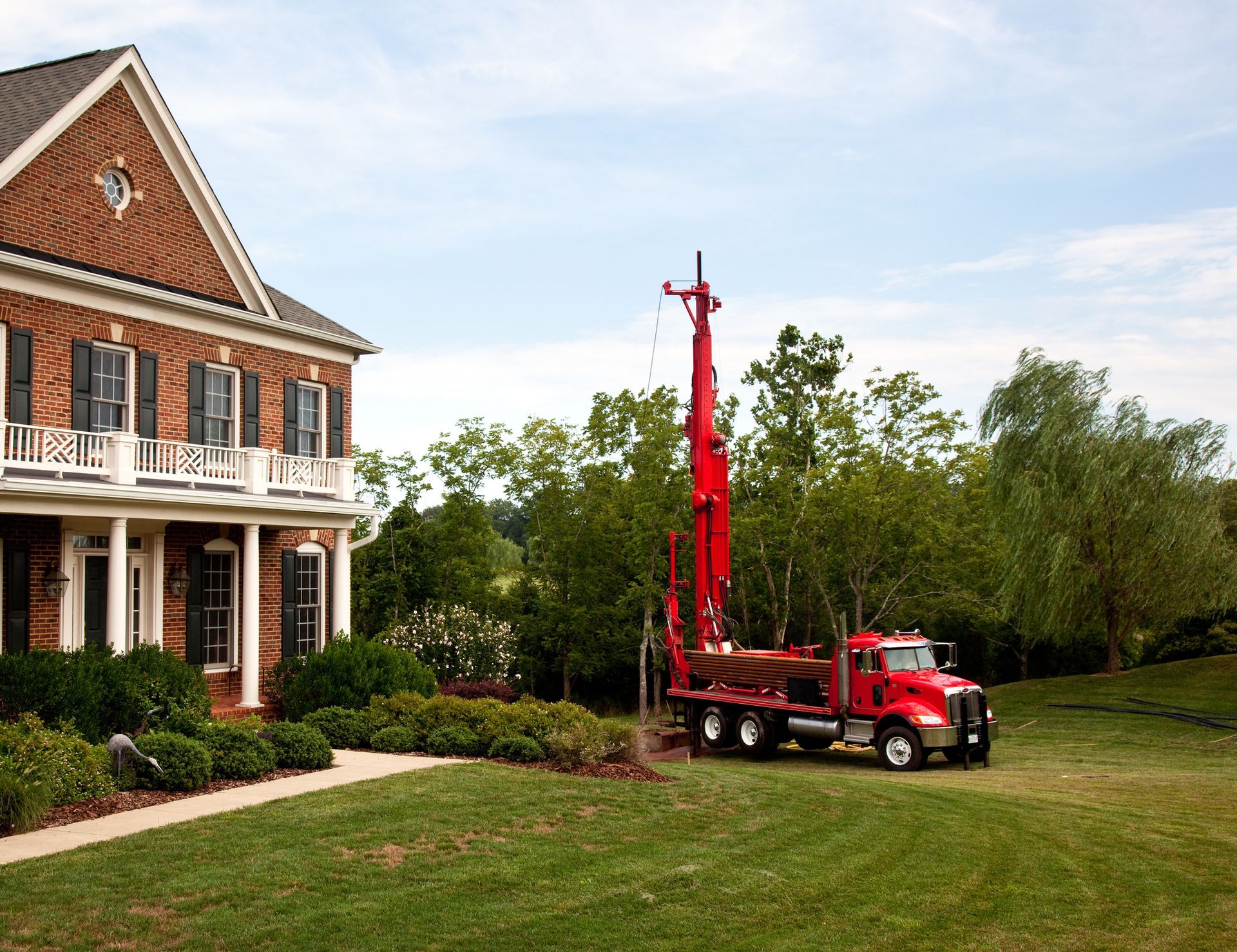 Red truck drilling into the yard.
