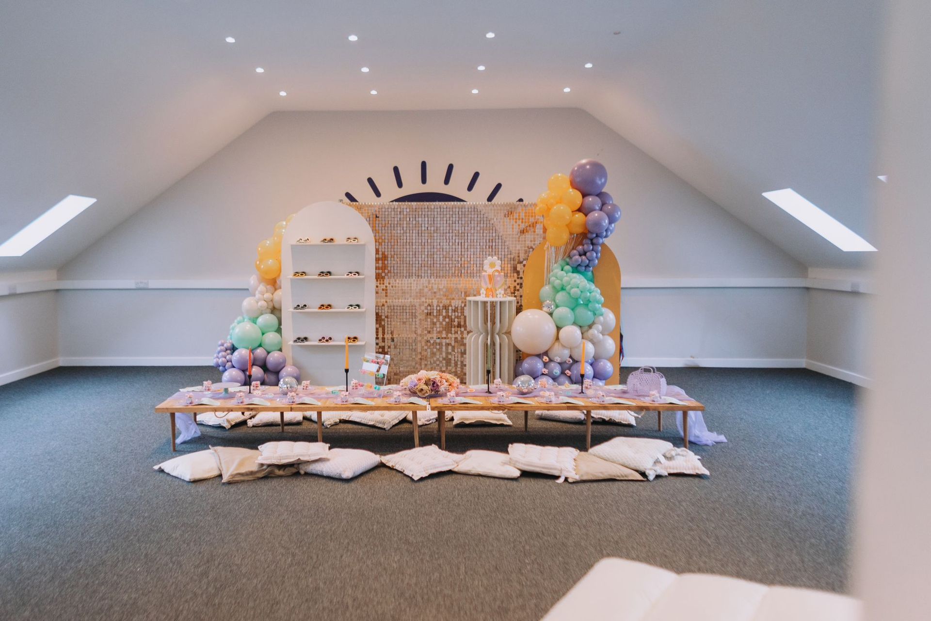 A room with a lot of pillows and balloons on the floor.