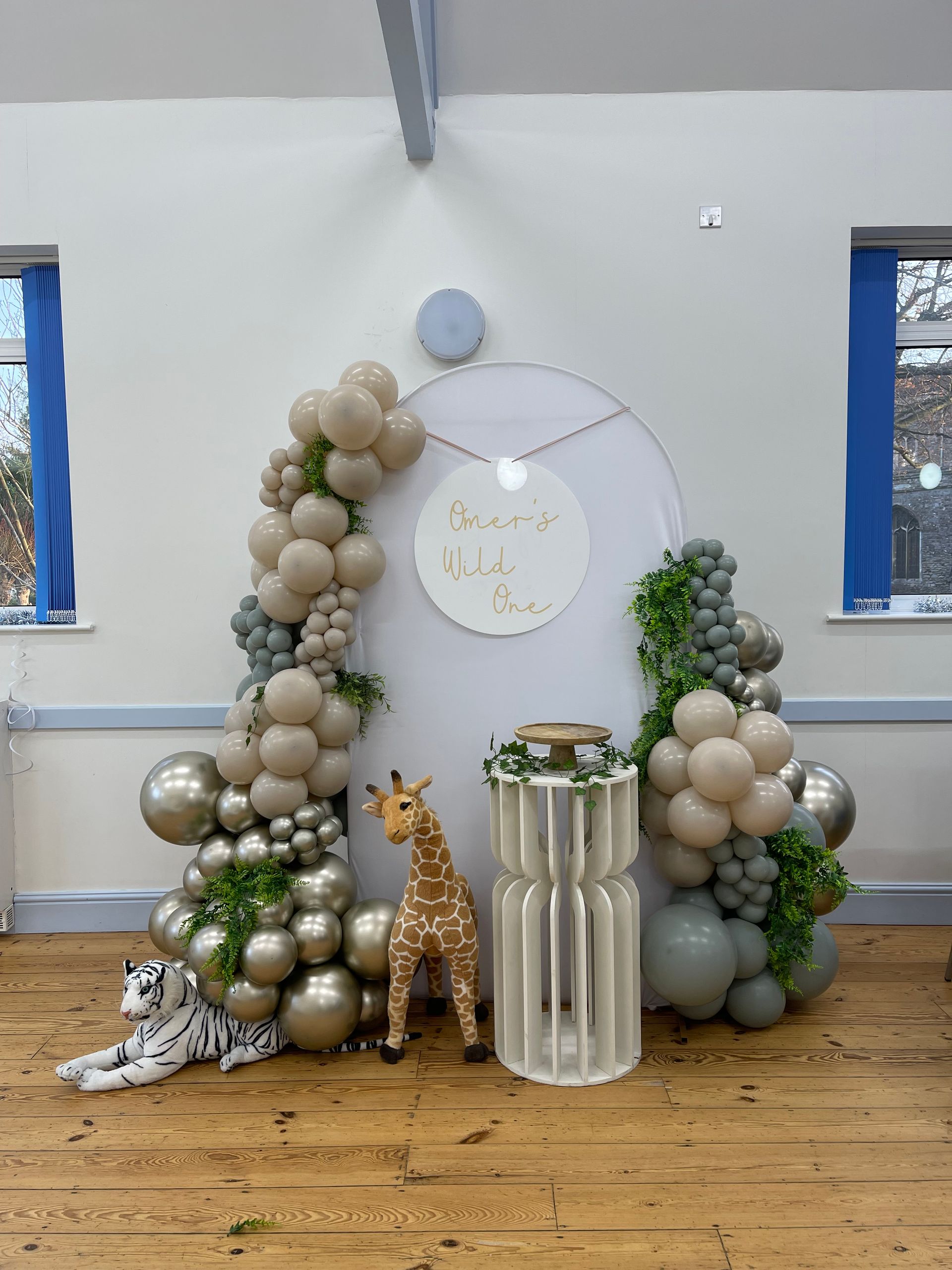 A room filled with balloons and a giraffe statue.