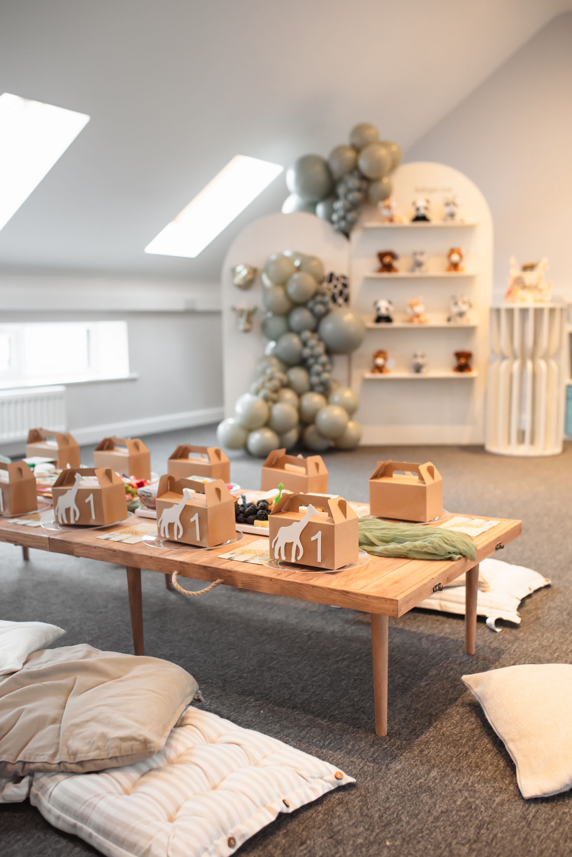 A room with a table and boxes on it and pillows on the floor.