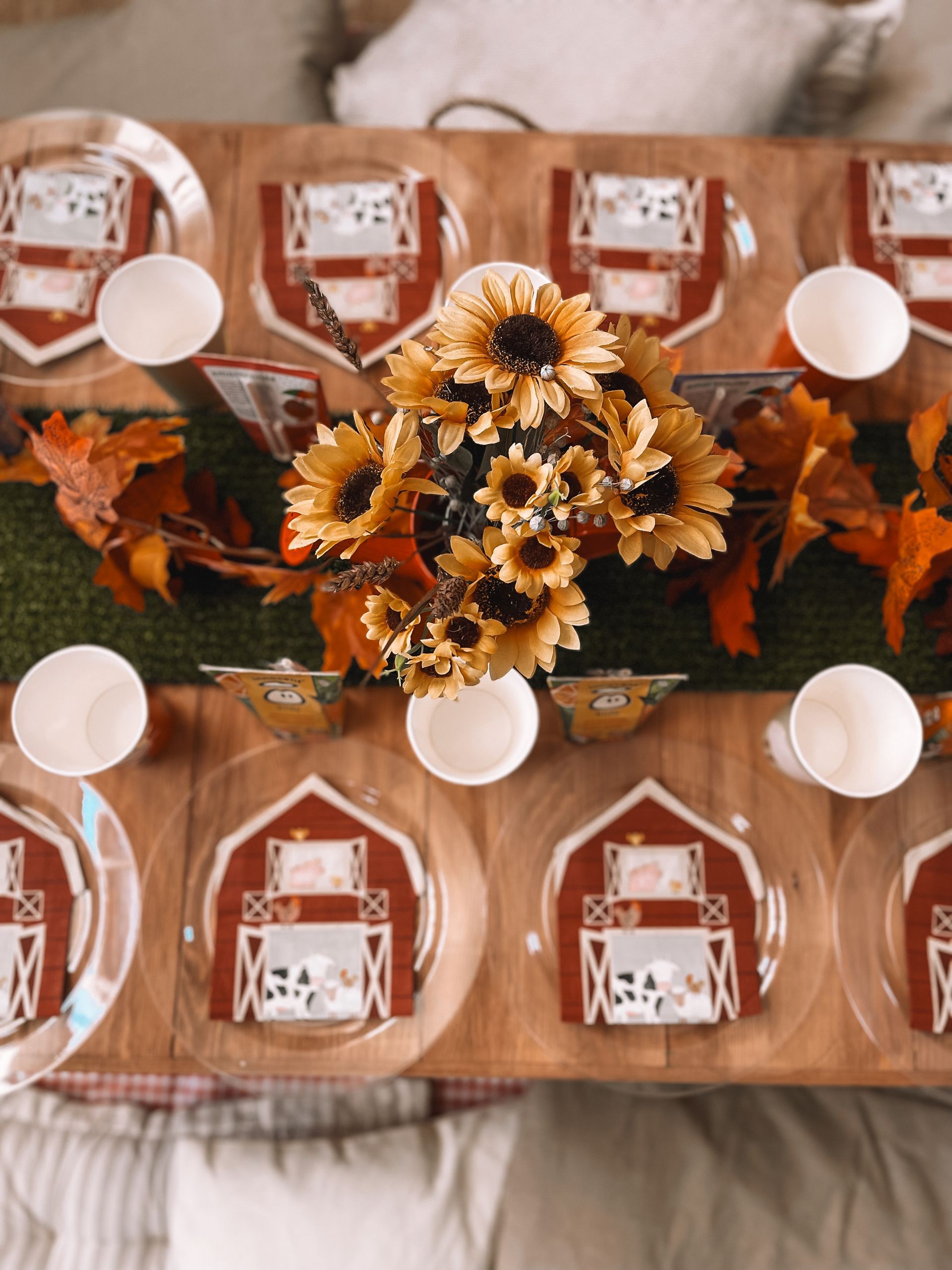 A table with plates , cups , napkins and flowers on it.