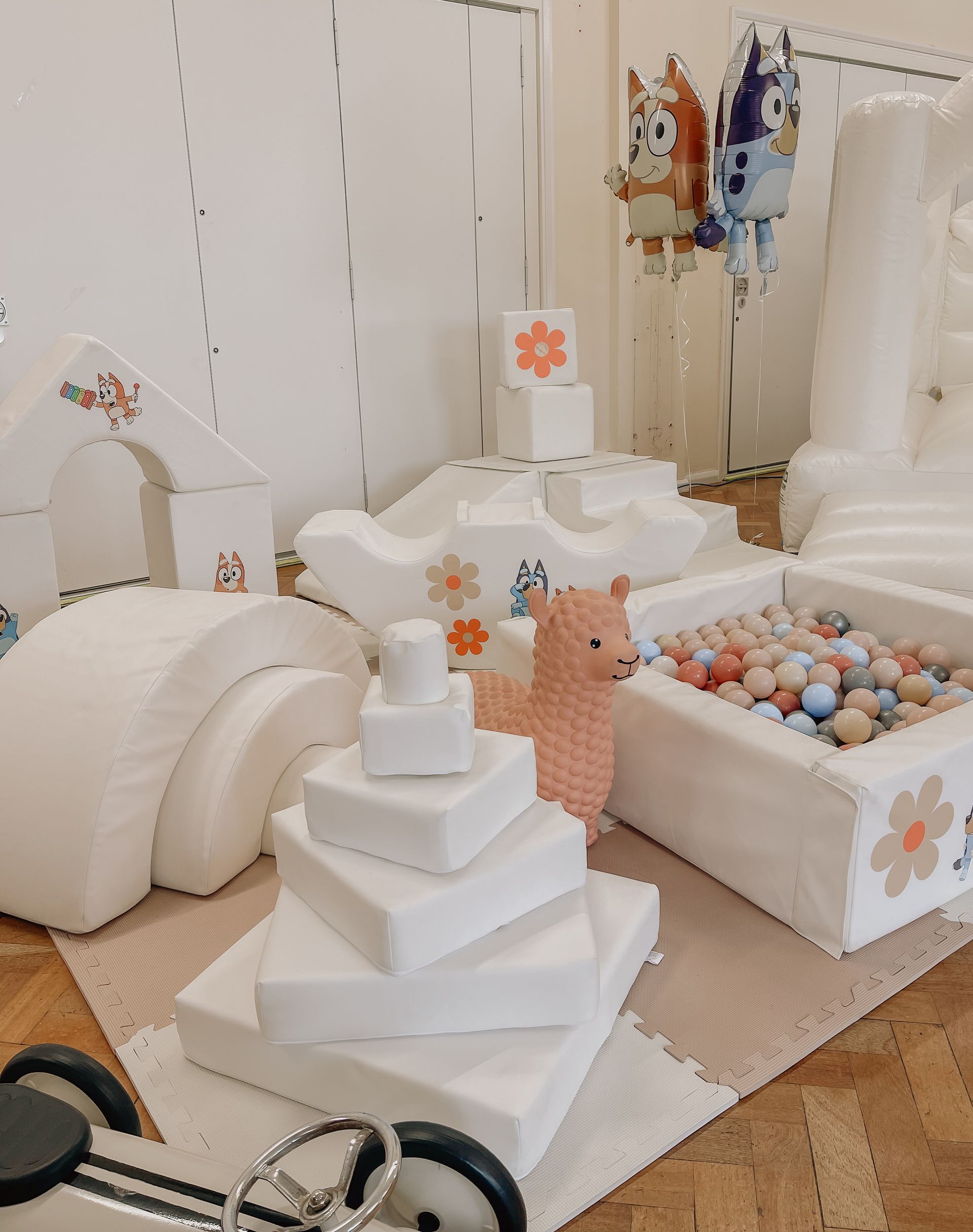 A room filled with lots of white toys and balloons.
