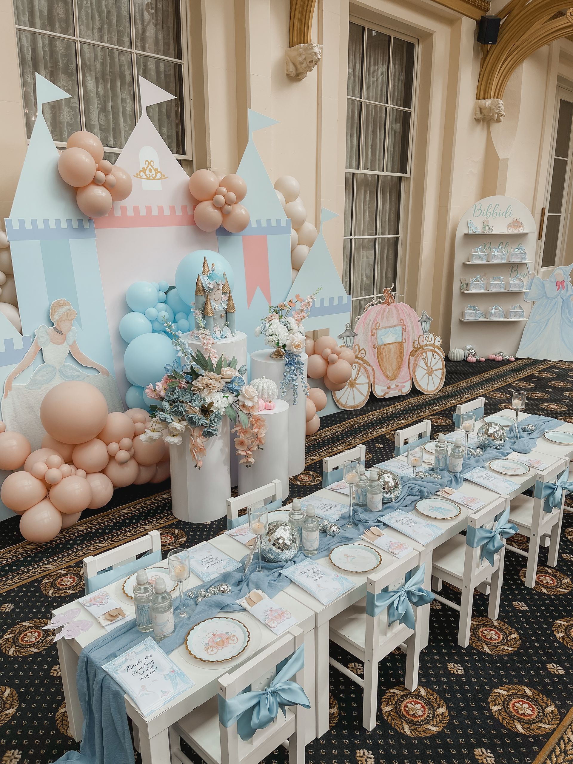 A room filled with tables and chairs decorated for a birthday party.