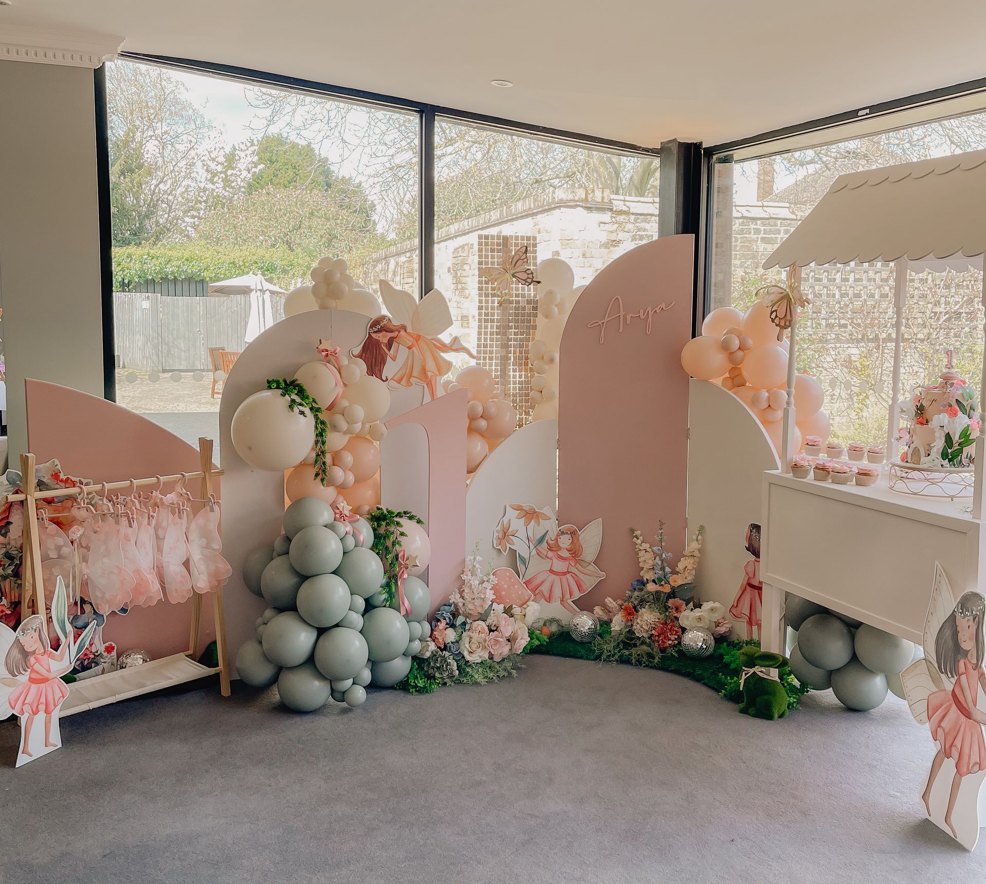 A room decorated with balloons and flowers for a baby shower.