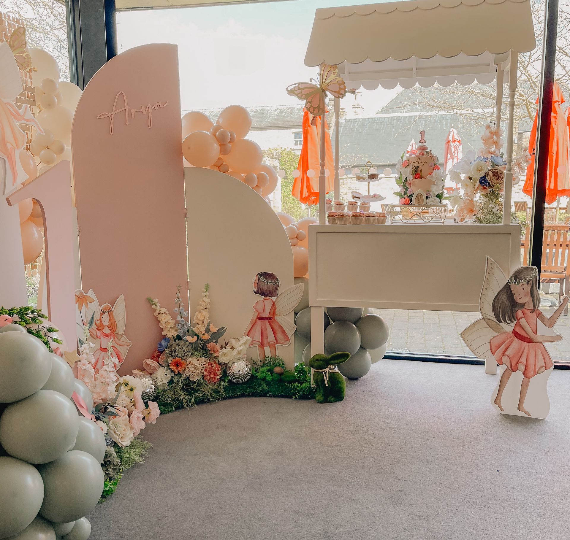 A room filled with balloons and a candy cart