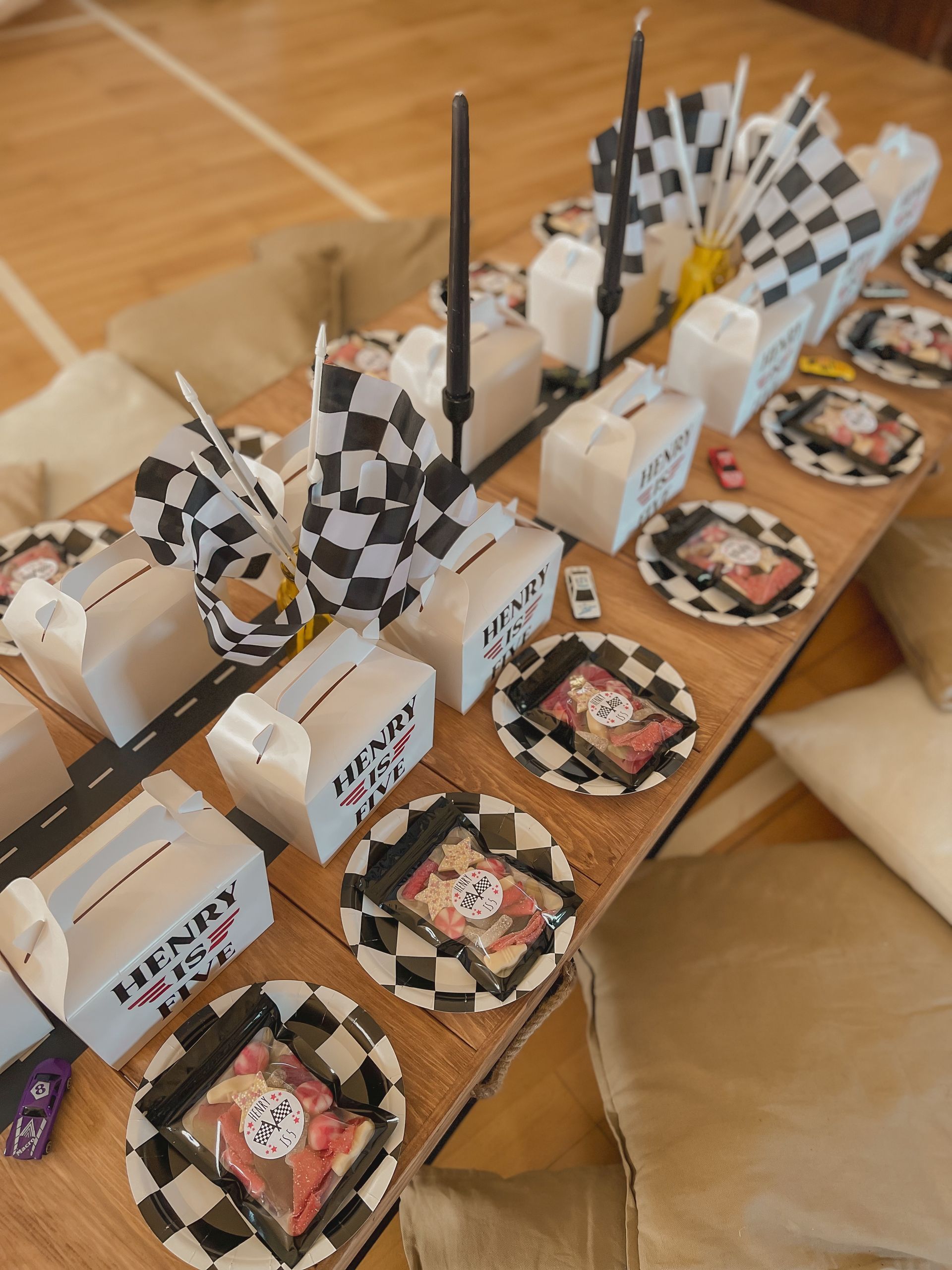 A long wooden table with plates and boxes on it