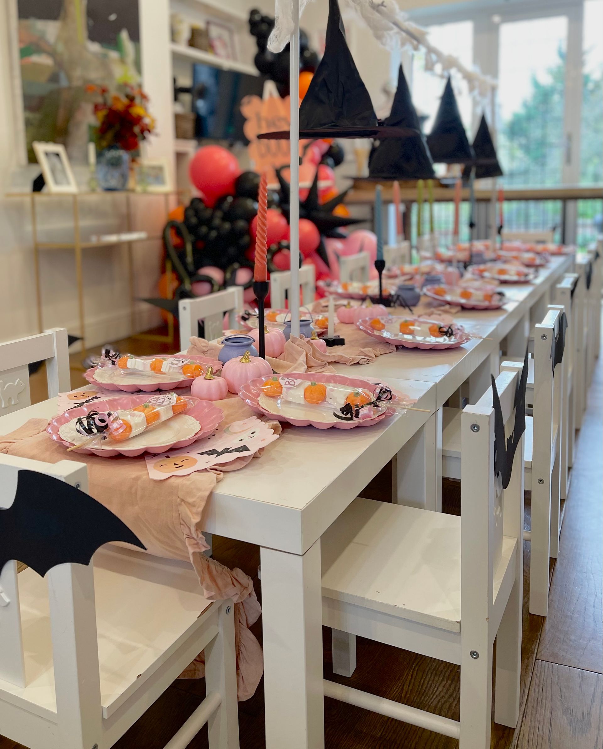 A long table with plates and chairs set up for a halloween party.