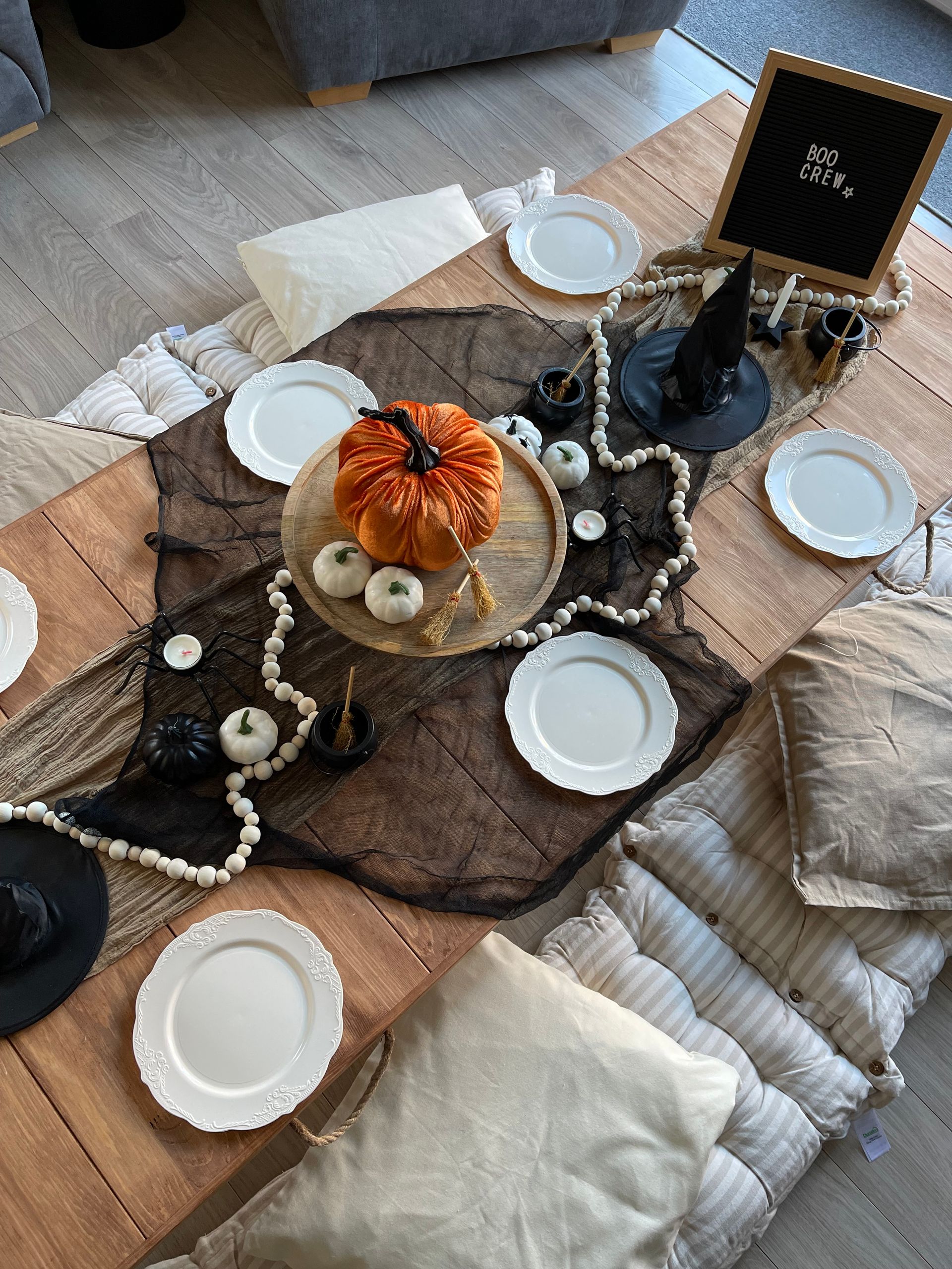 A table with plates , a pumpkin , and a witch hat on it.