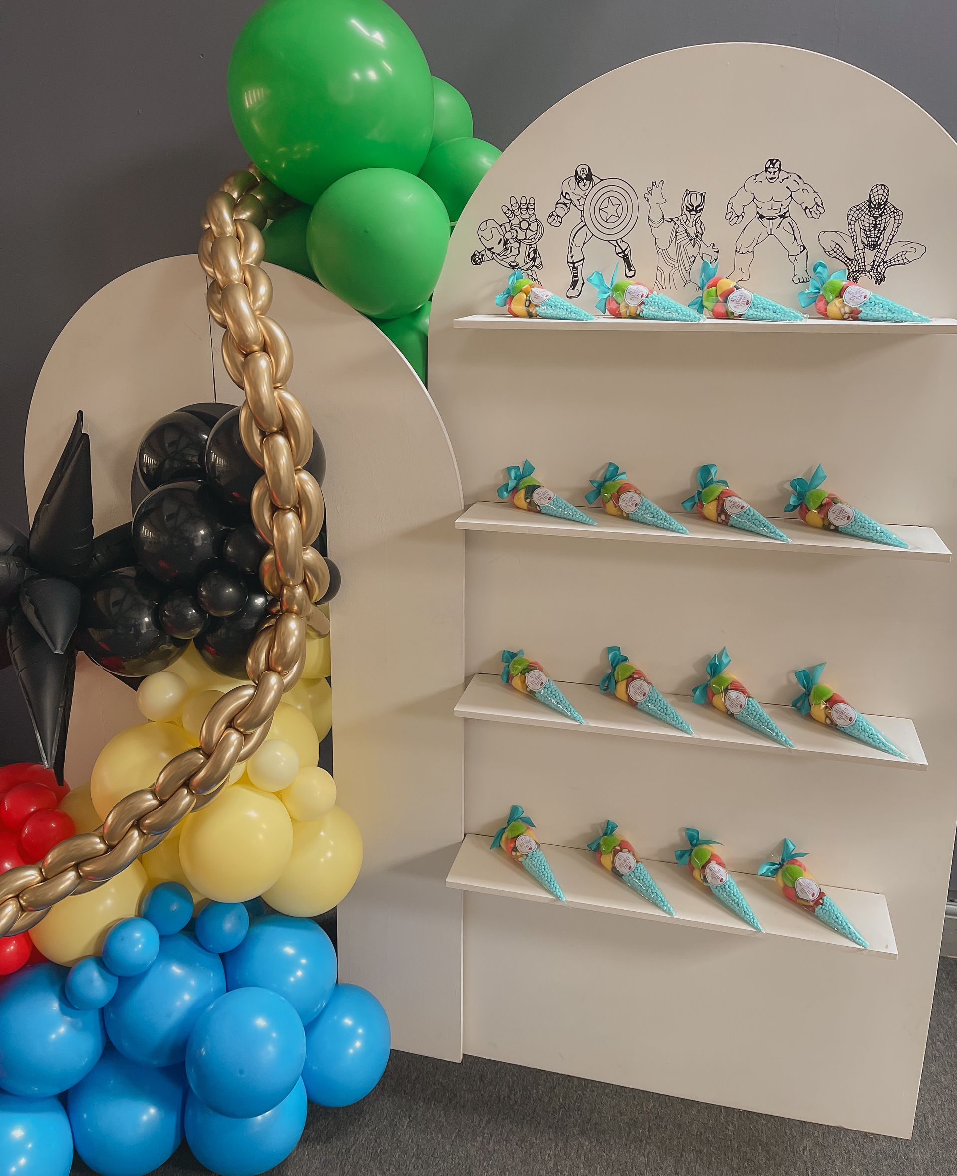 A display of balloons and candy cones on shelves