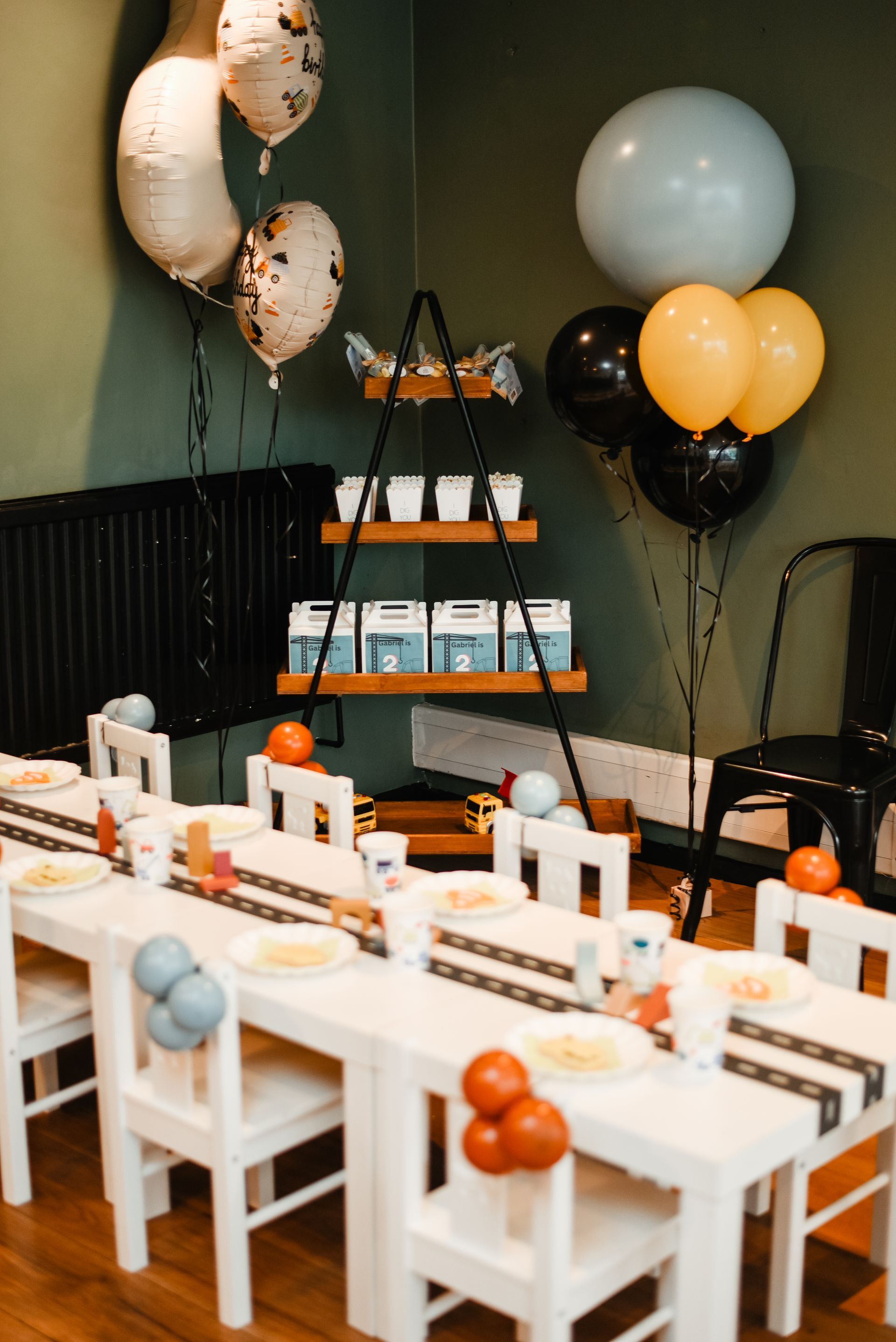 A room decorated for a birthday party with tables and chairs and balloons.