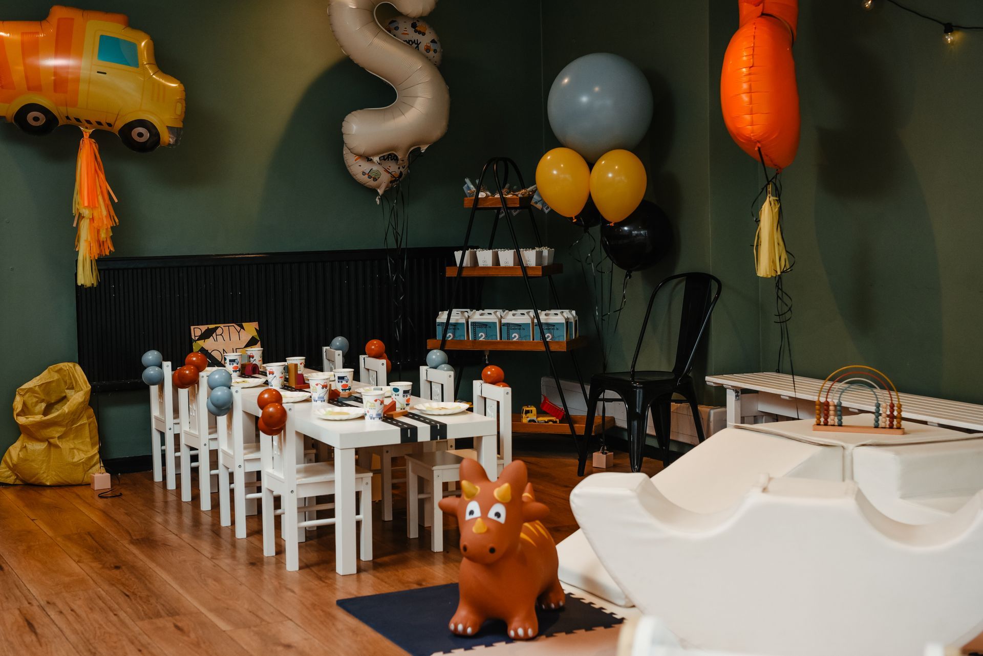 A room decorated for a child 's birthday party with tables and chairs and balloons.