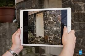 Photo of a person holding an iPad with the camera open recording a door on the side of a building