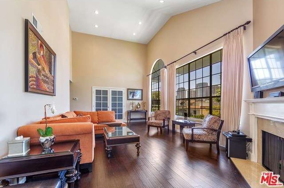A living room with a couch , chairs , coffee table , fireplace and television.