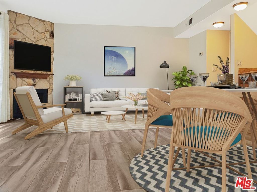 A living room with a couch , chairs , a table and a television.