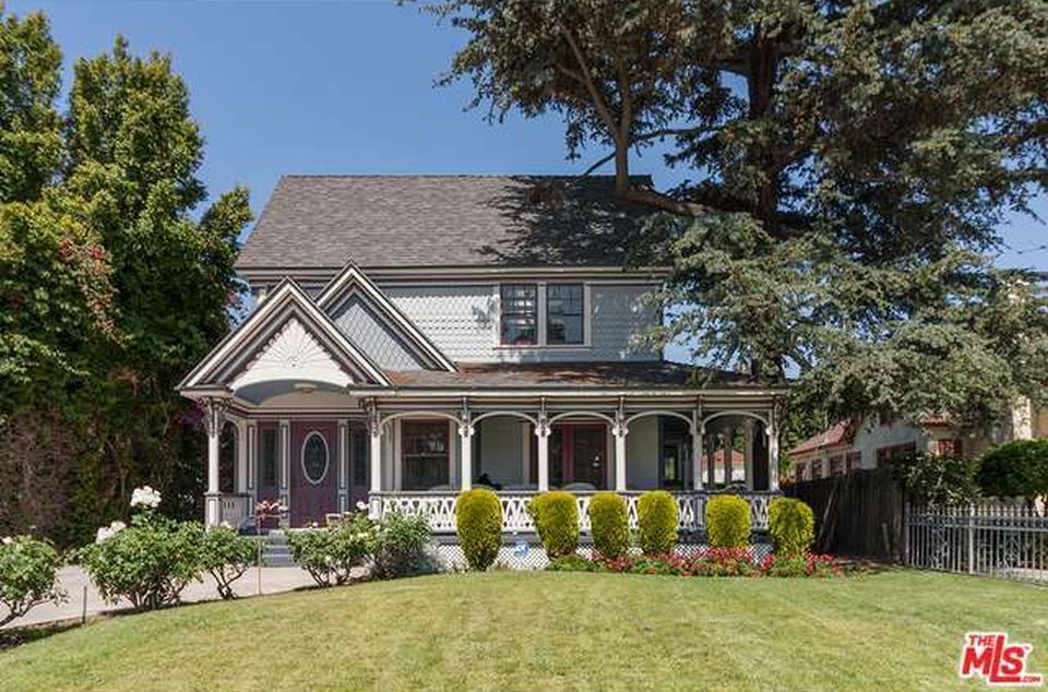 A large white house with a large porch is for sale