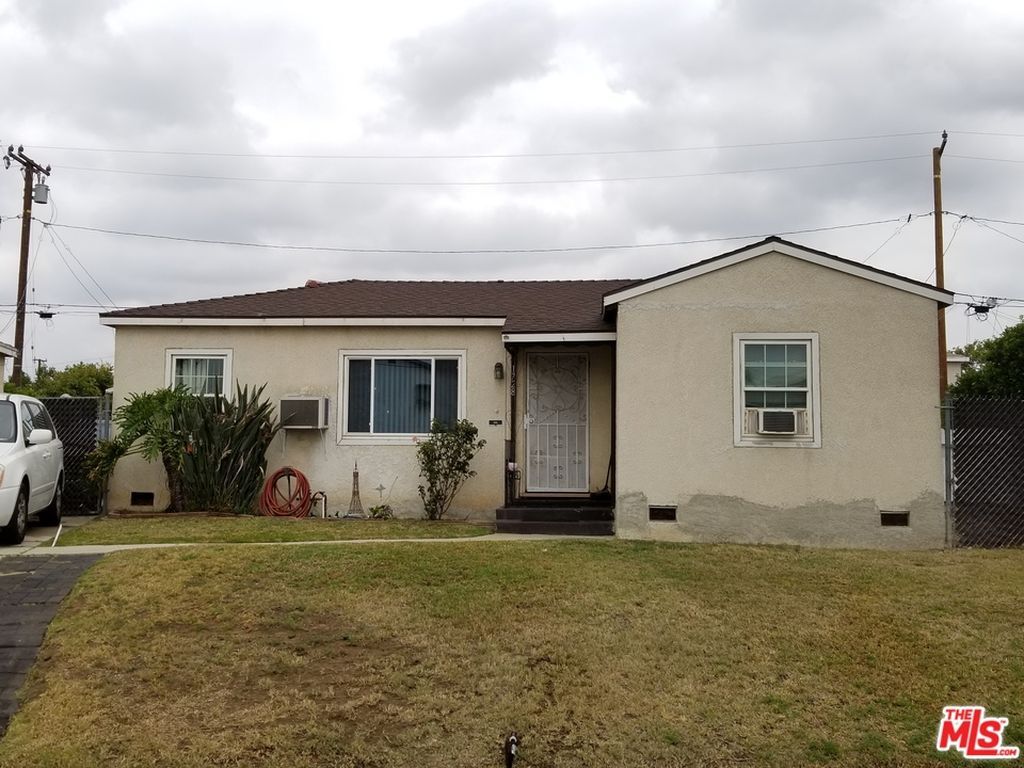 A small house with a car parked in front of it