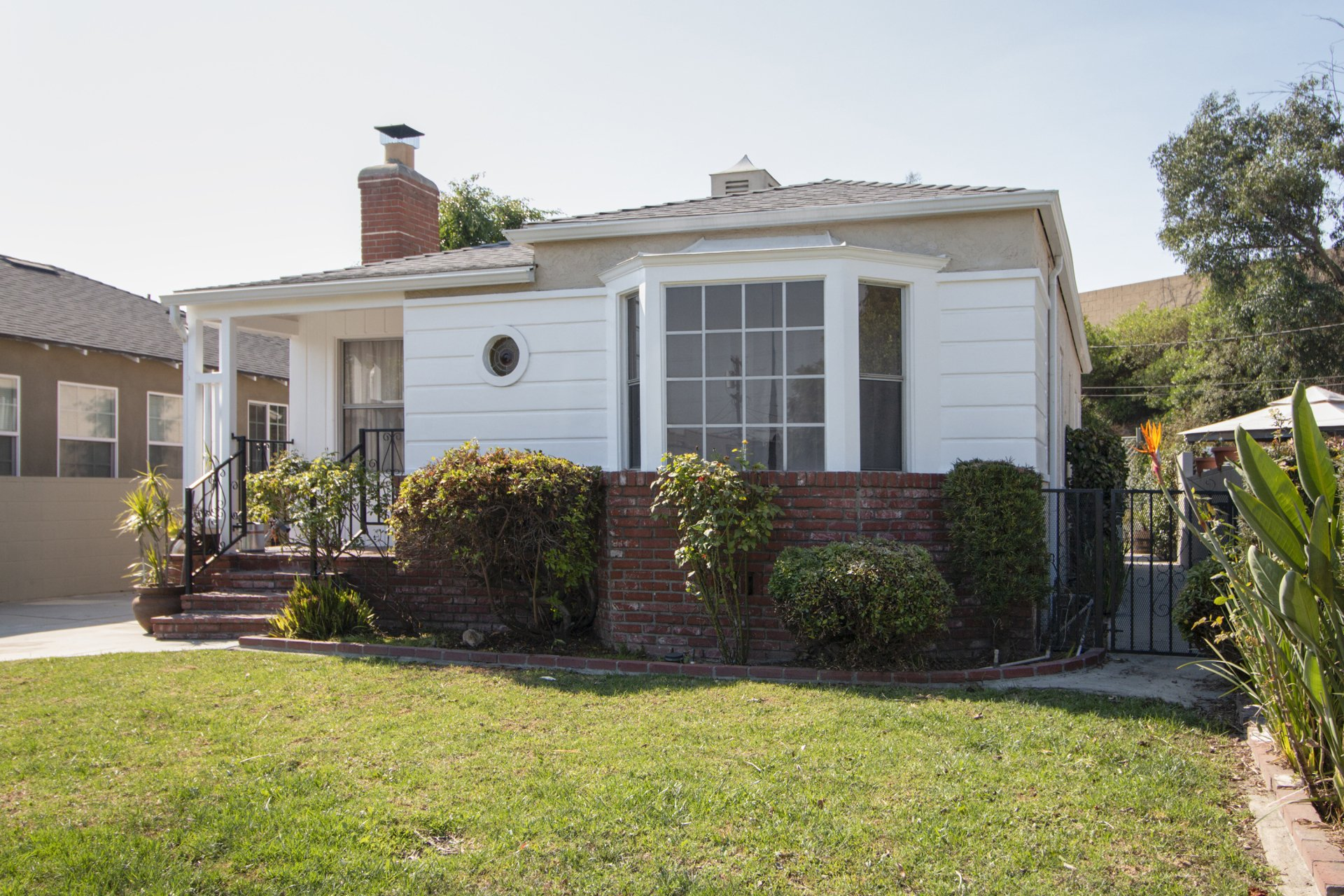 A small white house with a large lawn in front of it