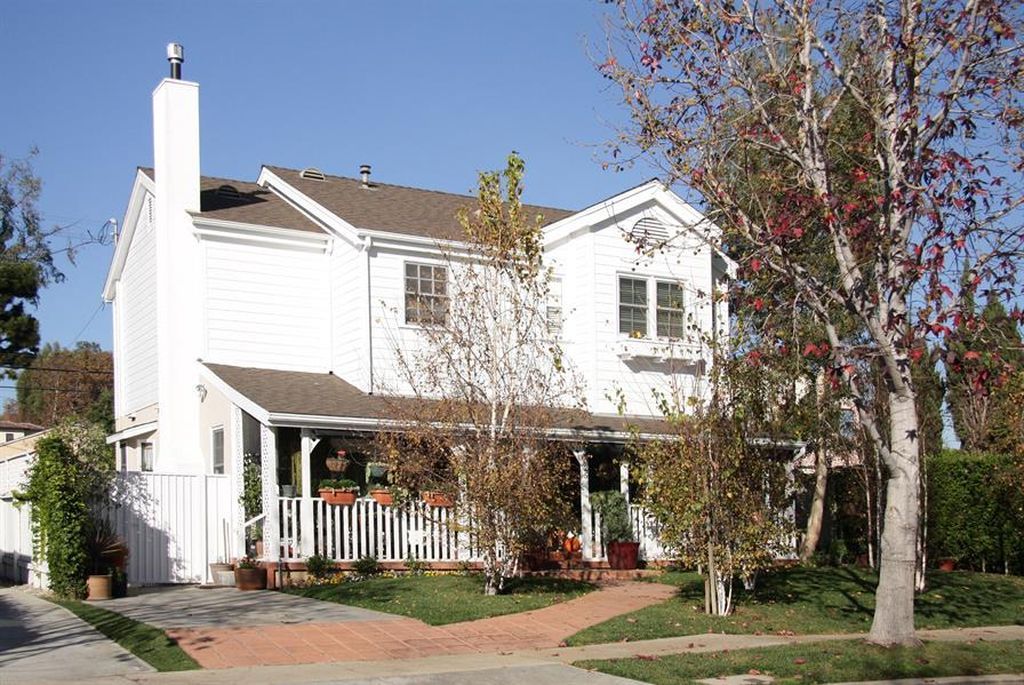 A white house with a porch and a chimney