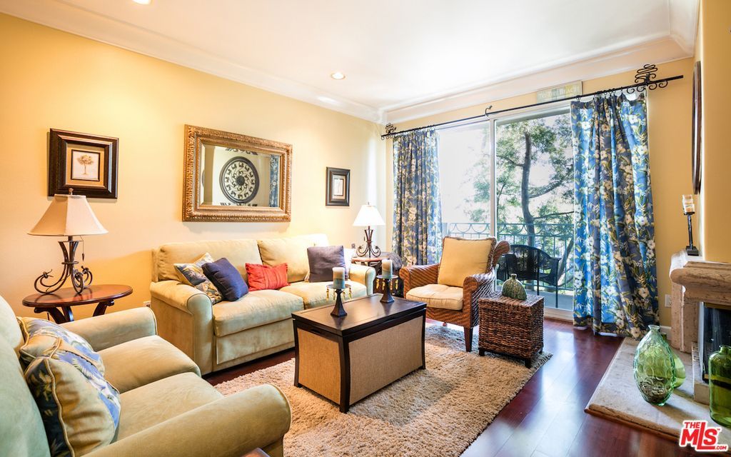 A living room with a couch , chairs , coffee table and fireplace.