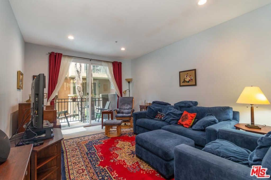 A living room with a blue couch , chairs , and a television.