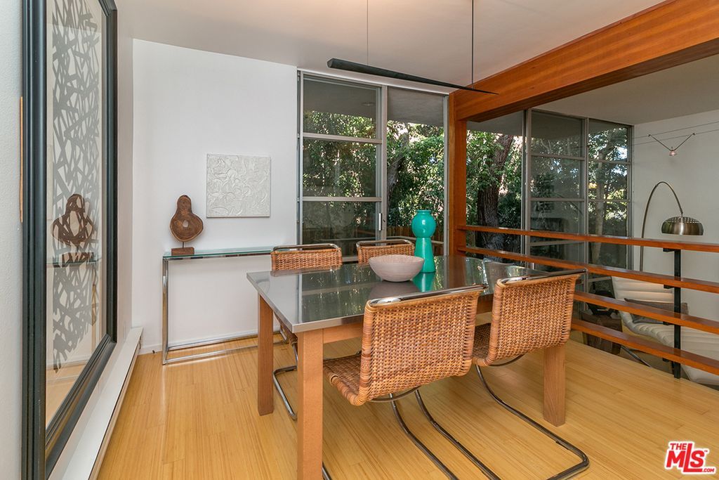 A dining room with a table and chairs and a large window.