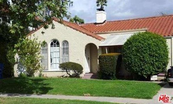 A white house with a red tile roof is for sale.