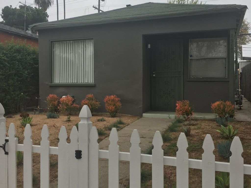 A small house with a white picket fence in front of it