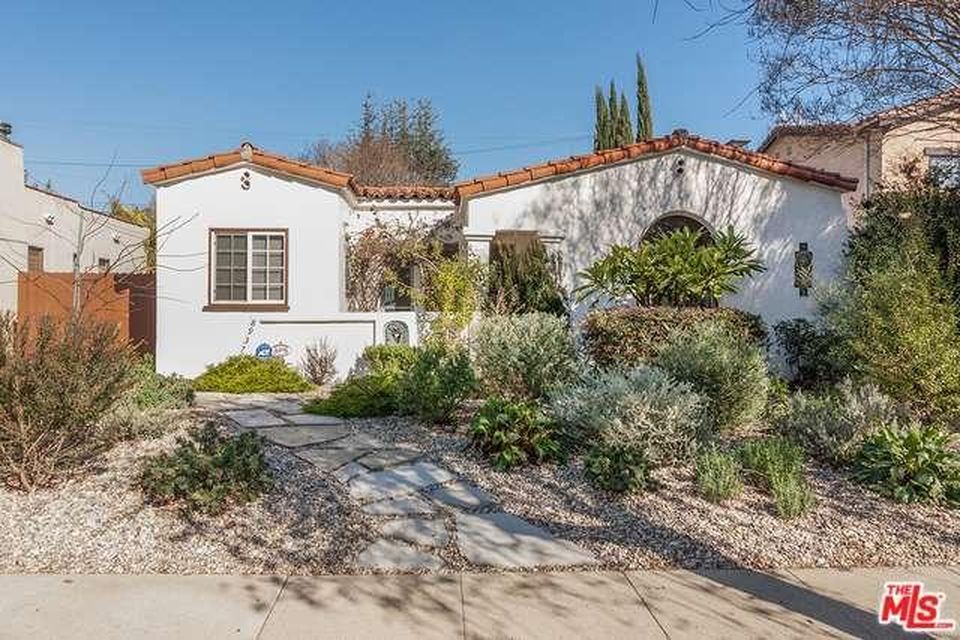 A white house with a red tile roof is for sale.