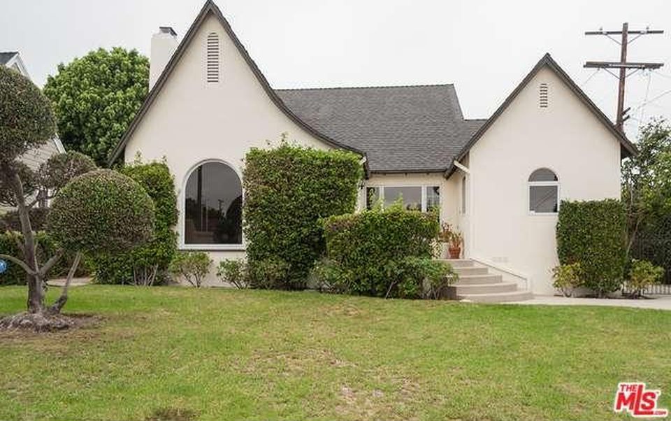 A white house with a black roof is for sale