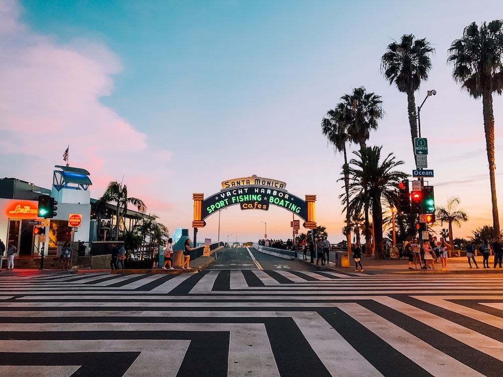 A crosswalk with palm trees and a sign that says santa clara beach