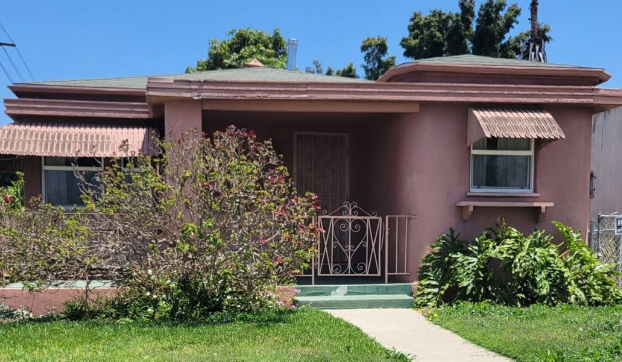 A pink house with a fence in front of it