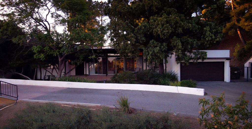 A house with a garage and trees in front of it