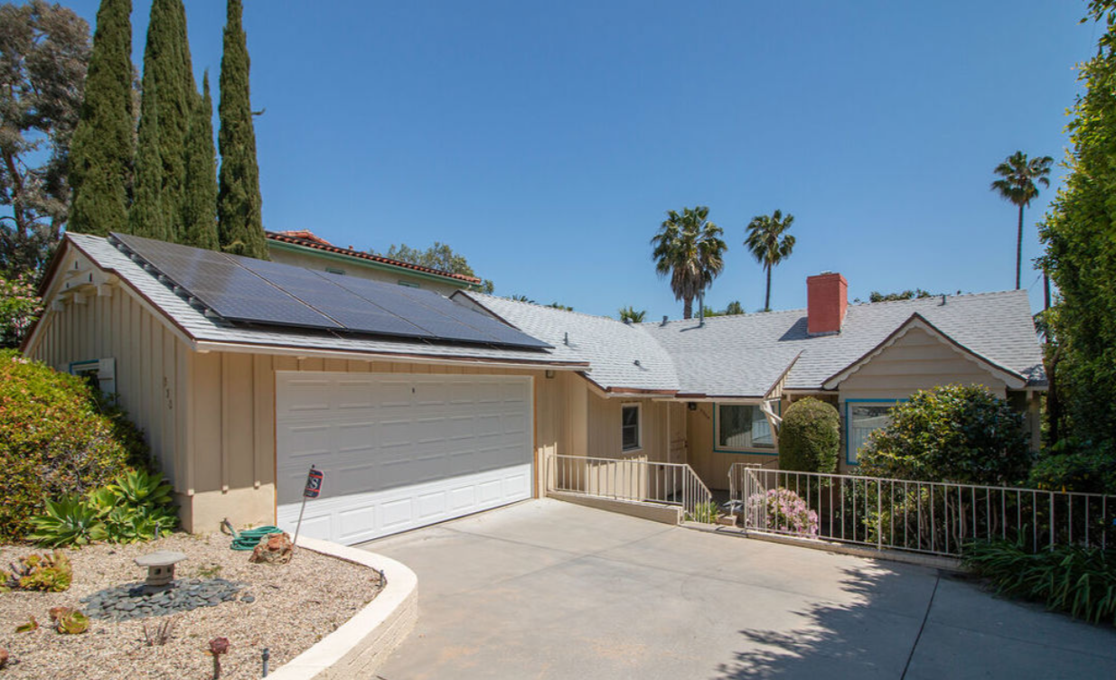 A house with a garage and solar panels on the roof.