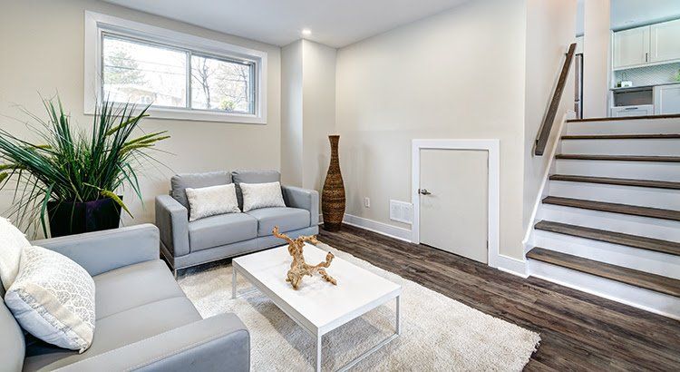 A living room with a couch , coffee table , and stairs.