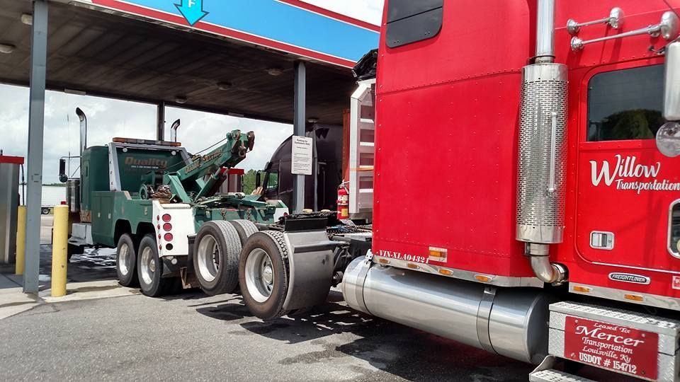 a red semi truck is parked in front of a gas station .