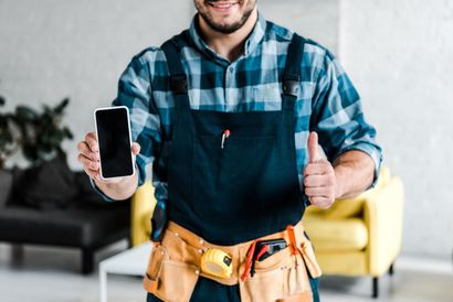 A man wearing gloves is holding a piece of paper in his hands.