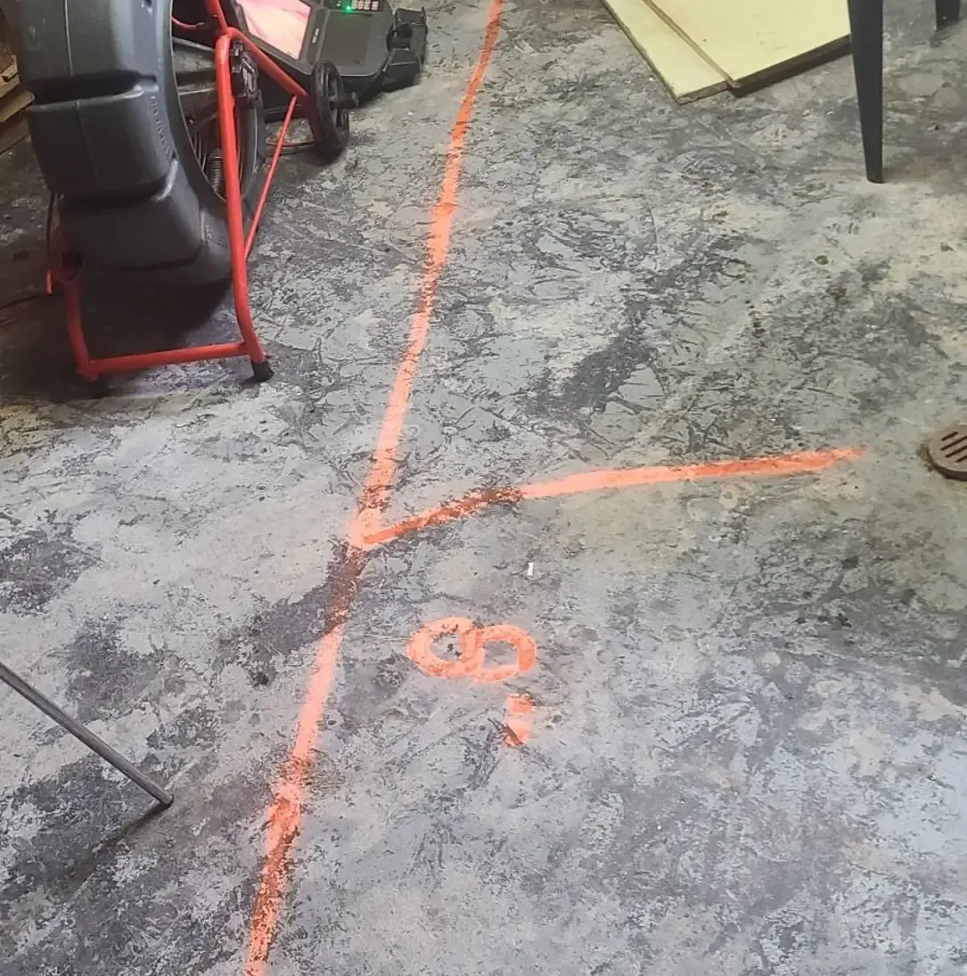 Un sol en béton avec une ligne rouge tracée dessus.