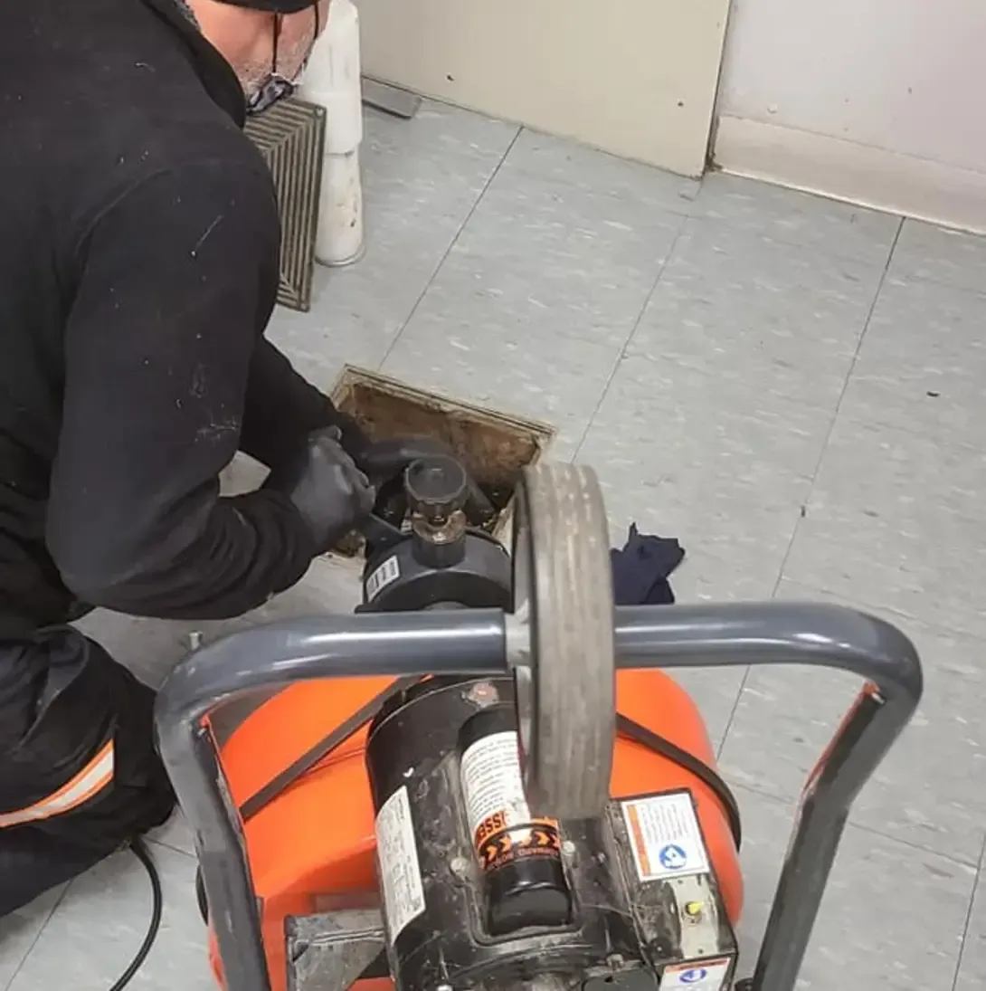 Un homme est à genoux sur le sol en utilisant une machine