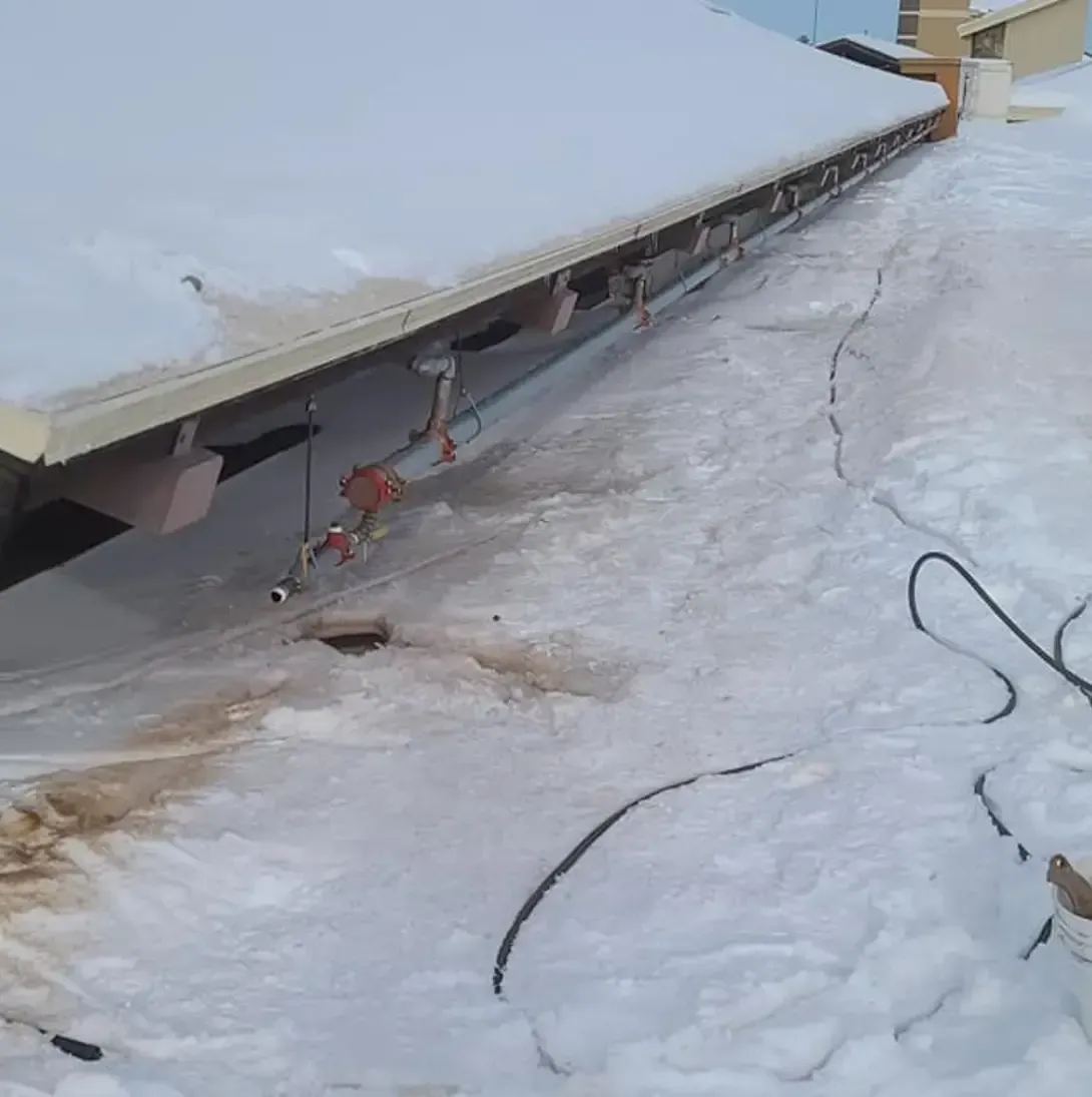 Un toit enneigé avec un tuyau attaché dessus