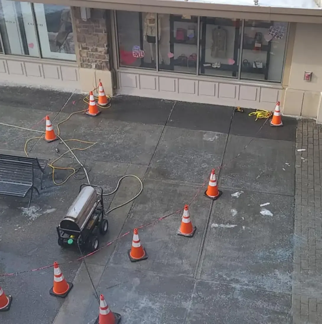 Un tas de cônes de signalisation sont sur le trottoir devant un bâtiment